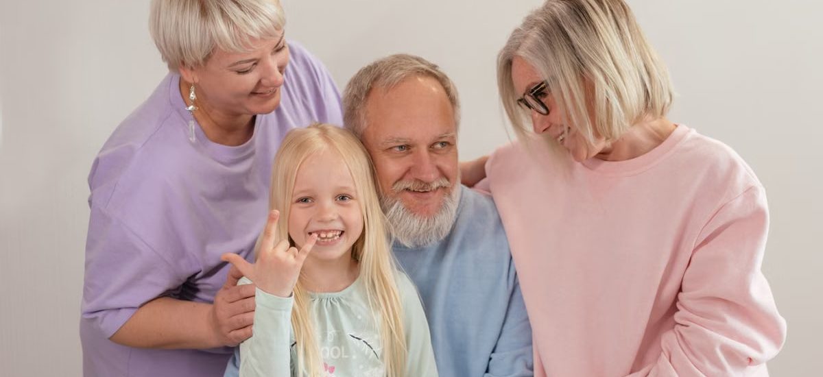 A joyful multigenerational family poses and smiles together indoors, showcasing love and togetherness.