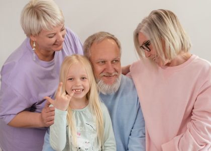 A joyful multigenerational family poses and smiles together indoors, showcasing love and togetherness.